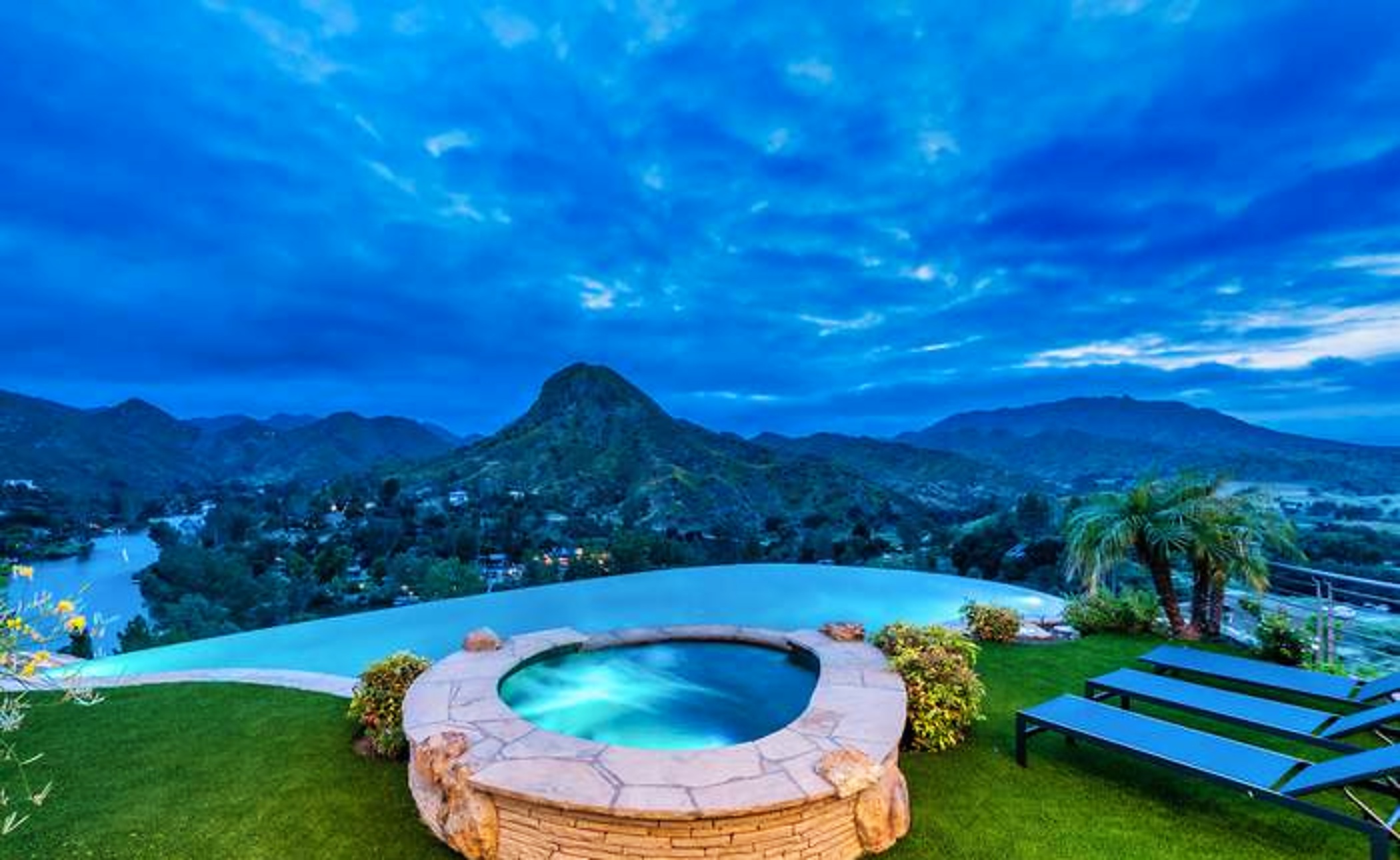 Illuminated spa and infinity pool at blue hour
